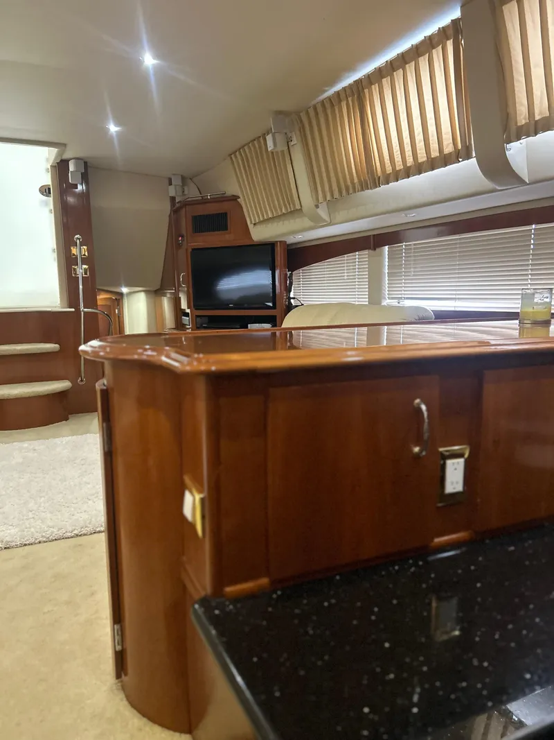 Slide: The Image of Luxurious kitchen interior of 2003 Carver 466 Motor Yacht with wooden cabinets and black countertop. - 15
