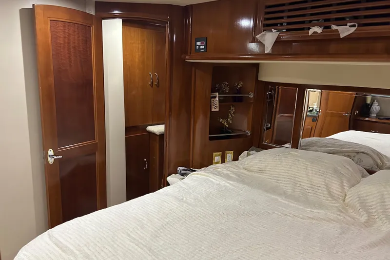 Slide: The Image of 2003 Carver 466 Motor Yacht cabin with bed, storage bags, and colorful decor. - 20