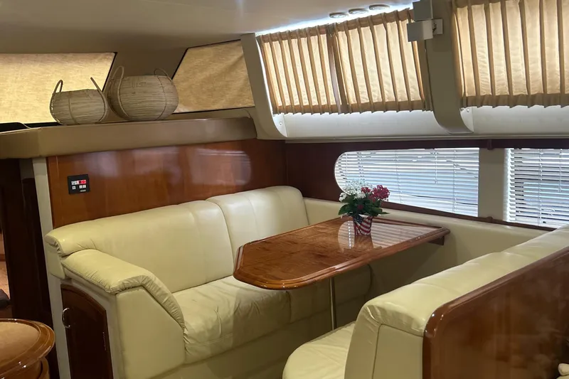 Slide: The Image of Luxurious interior of 2003 Carver 466 Motor Yacht with leather seating and wooden table. - 48