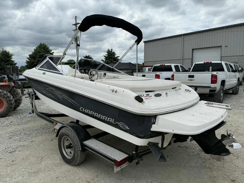 Slide: The Image of 2007 Chaparral 180 SSi boat on trailer, parked outdoors near trucks and a building. - 3