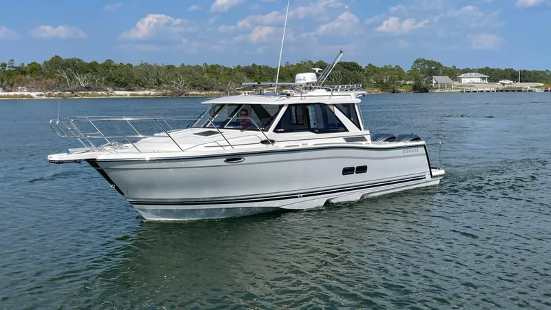 The Image of 2026 Cutwater C-288 Coupe cruising on a calm lake under a clear blue sky. - 0