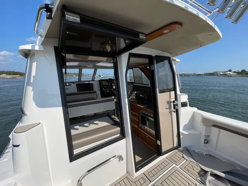 Slide: The Image of 2026 Cutwater C-288 Coupe interior view with open door, showcasing seating and control panel. - 11