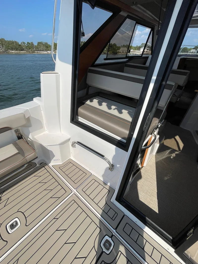 Slide: The Image of 2026 Cutwater C-288 Coupe interior with open door, showcasing seating and deck details. - 13