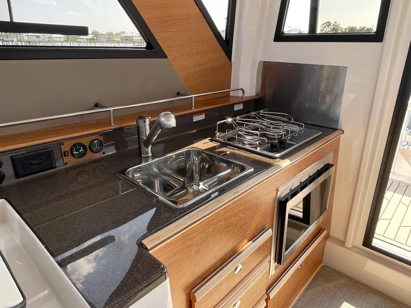 Slide: The Image of 2026 Cutwater C-288 Coupe kitchen with stove, sink, and oven in a compact design. - 34