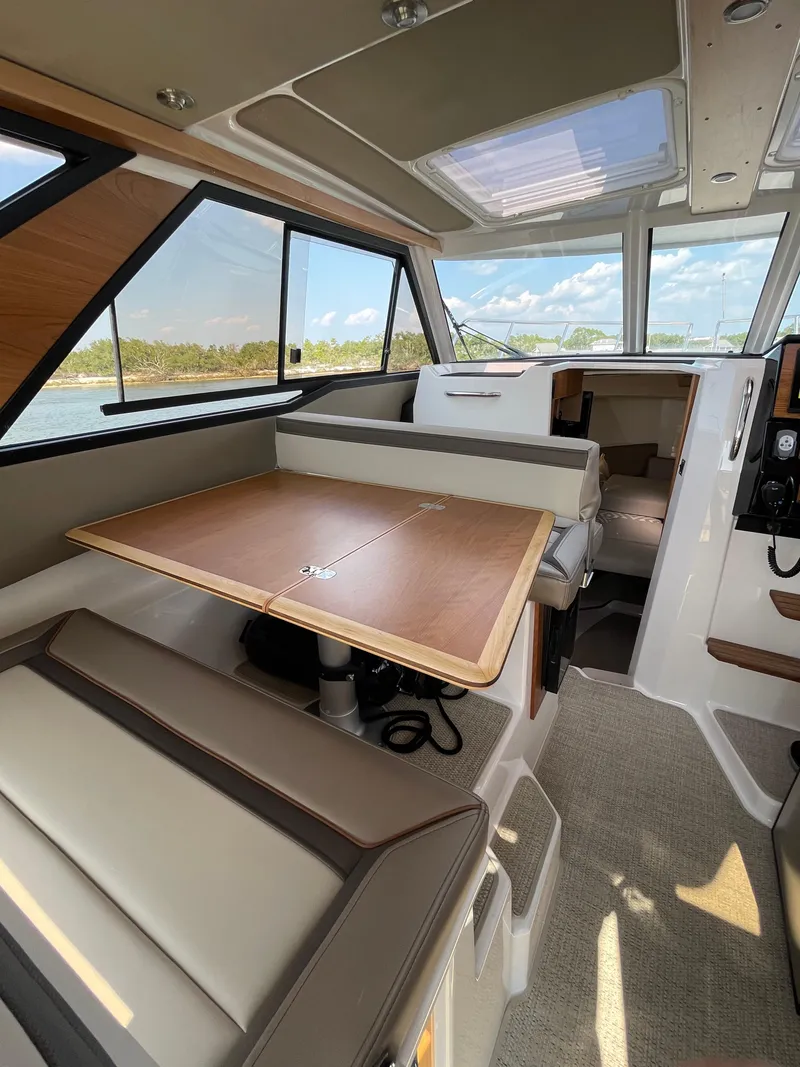 Slide: The Image of Interior of 2026 Cutwater C-288 Coupe, featuring a dining area with panoramic windows. - 36