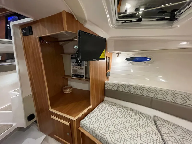 Slide: The Image of 2026 Cutwater C-288 Coupe interior with wood cabinetry, TV, and patterned seating. - 44