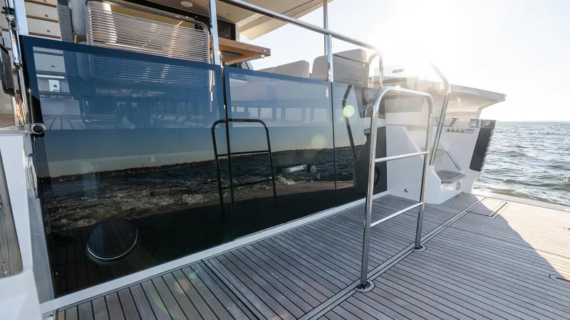 Slide: The Image of 2025 Absolute 60 Fly yacht deck with sleek glass railing and ocean view. - 13