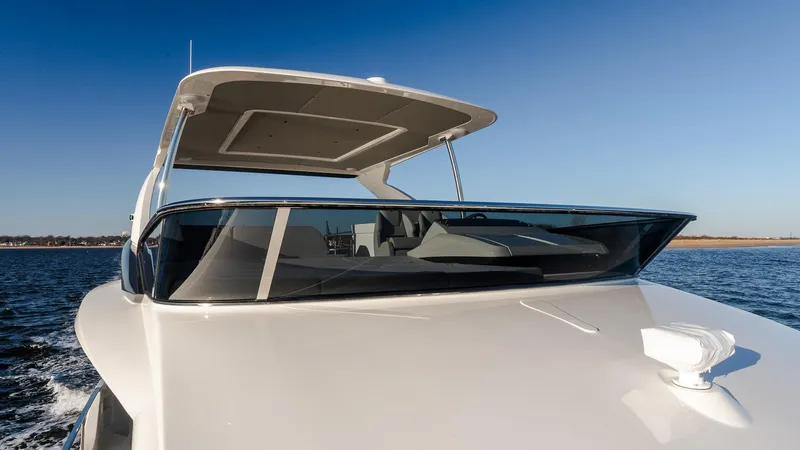 Slide: The Image of 2025 Absolute 60 Fly yacht cruising on open water under clear blue sky. - 15