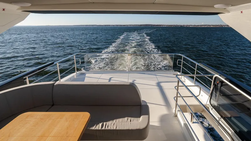 Slide: The Image of Luxurious 2025 Absolute 60 Fly yacht cruising on open water, featuring spacious deck seating. - 24