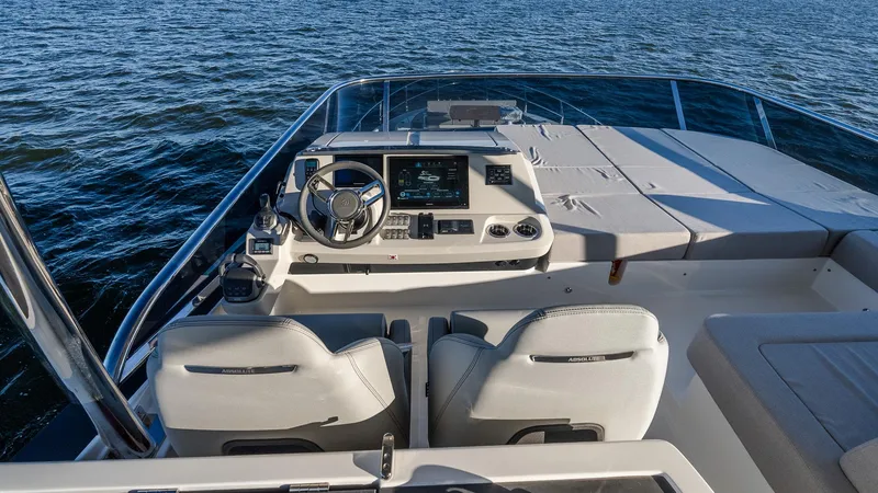 Slide: The Image of 2025 Absolute 60 Fly yacht helm with dual seats, overlooking calm waters. - 28