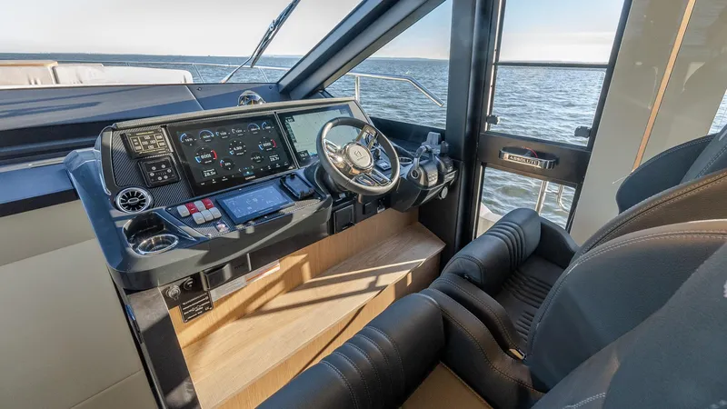 Slide: The Image of Helm of 2025 Absolute 60 Fly yacht with modern controls and ocean view. - 49