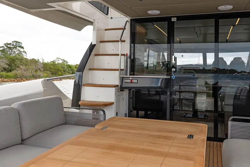 Slide: The Image of Luxurious 2026 Absolute 60 Fly yacht interior with modern seating and elegant wooden table. - 11