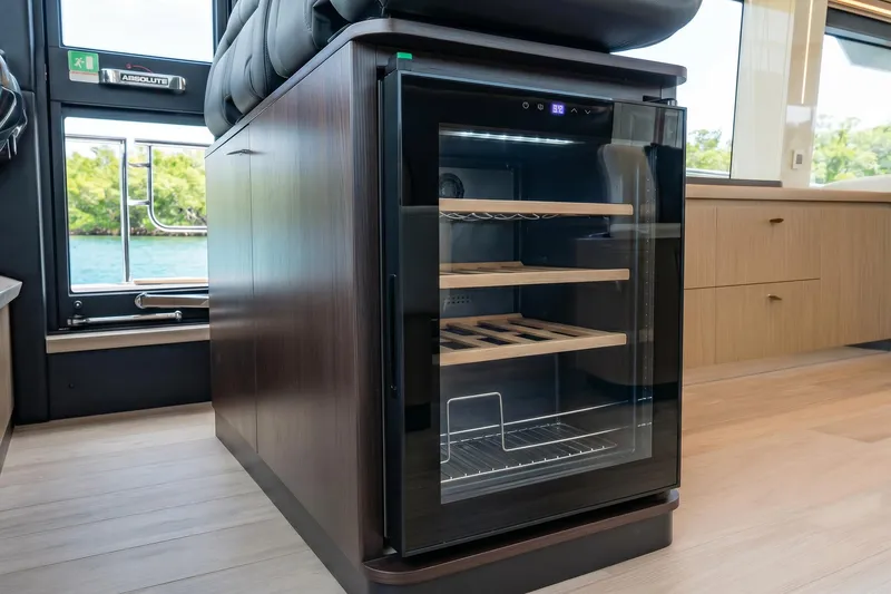 Slide: The Image of Modern interior of 2026 Absolute 60 Fly yacht featuring a sleek wine cooler. - 29
