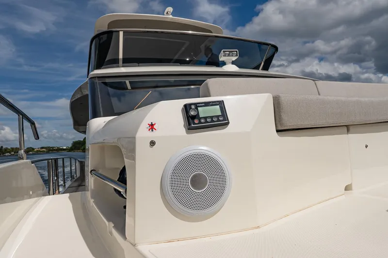 Slide: The Image of 2026 Absolute 60 Fly yacht deck with speaker and control panel under cloudy sky. - 57