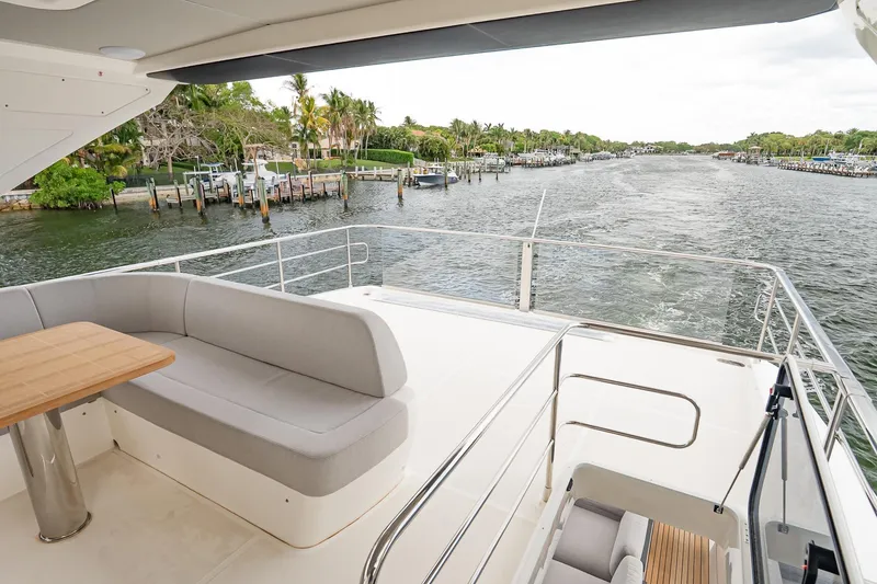 Slide: The Image of Luxurious Absolute 60 Fly yacht deck with seating, overlooking serene waterfront view, 2026 model. - 61
