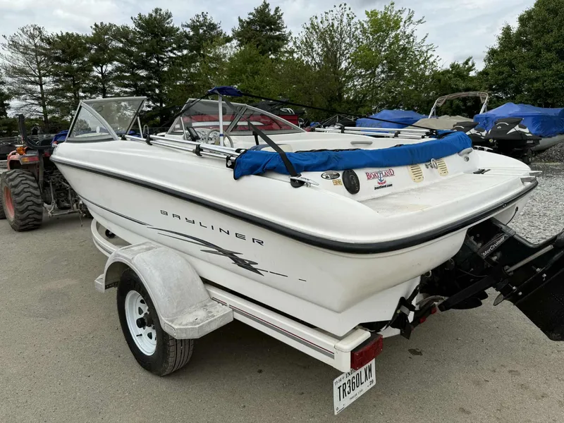Slide: The Image of 2005 Bayliner 175 Bowrider on trailer, parked outdoors with trees in background. - 3