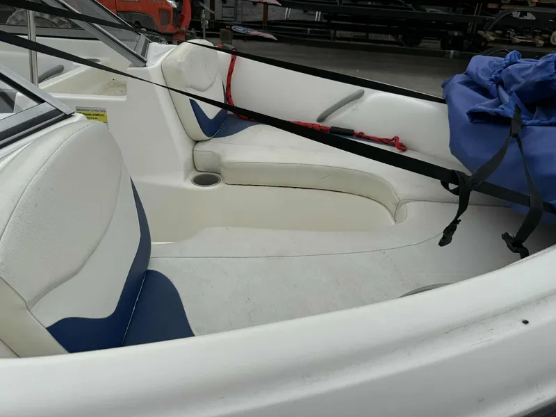 Slide: The Image of 2005 Bayliner 175 Bowrider interior with white and blue seating, cup holder, and storage bag. - 8
