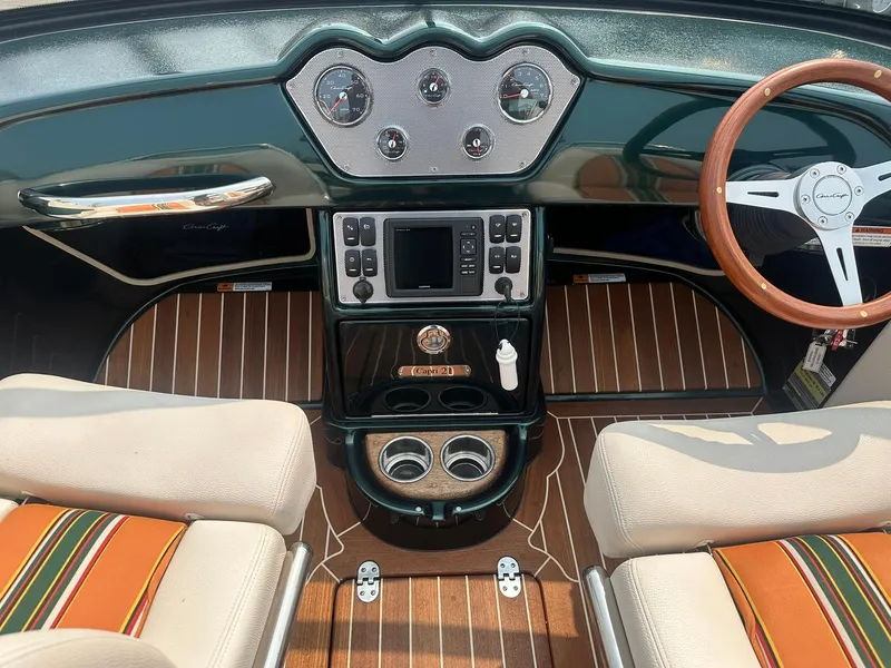 Slide: The Image of 2018 Chris-Craft Capri 21 dashboard with wood accents and modern controls. - 12