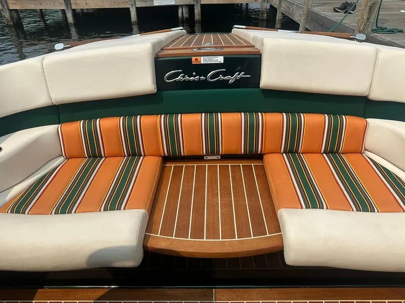 Slide: The Image of 2018 Chris-Craft Capri 21 boat interior with striped orange and green seating. - 17