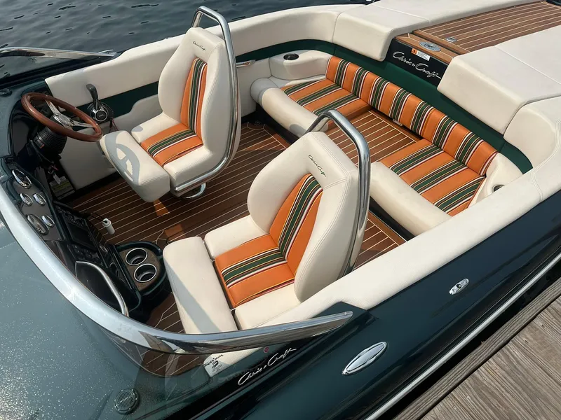 Slide: The Image of 2018 Chris-Craft Capri 21 boat interior with striped seats and wooden flooring. - 2