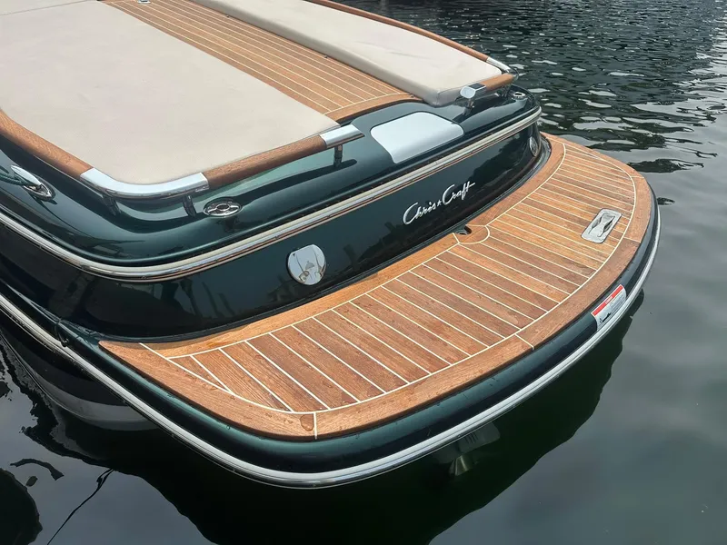 Slide: The Image of 2018 Chris-Craft Capri 21 boat with elegant wooden deck and sleek design on water. - 5