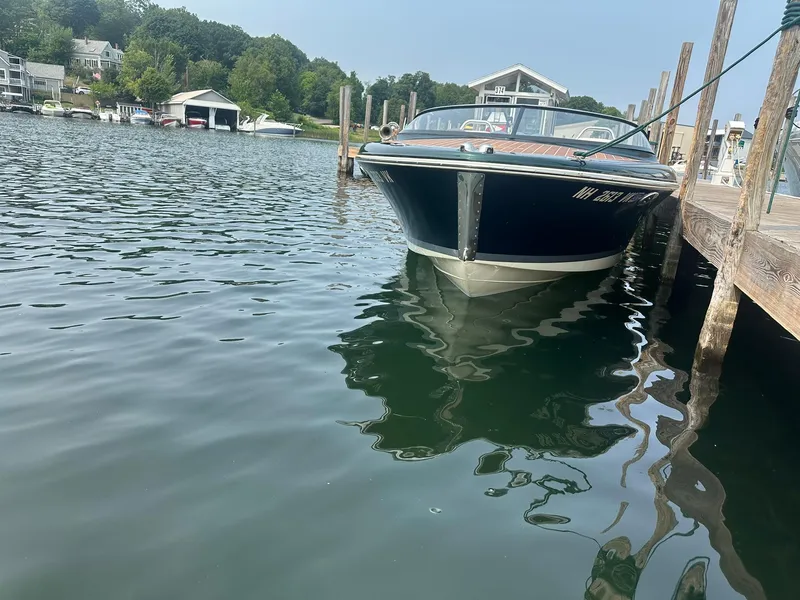 Slide: The Image of 2018 Chris-Craft Capri 21 boat docked in a serene marina setting. - 6