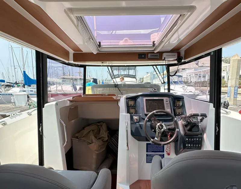 Slide: The Image of Interior view of 2012 Beneteau Barracuda 9 Fly boat cockpit with steering wheel and controls. - 13