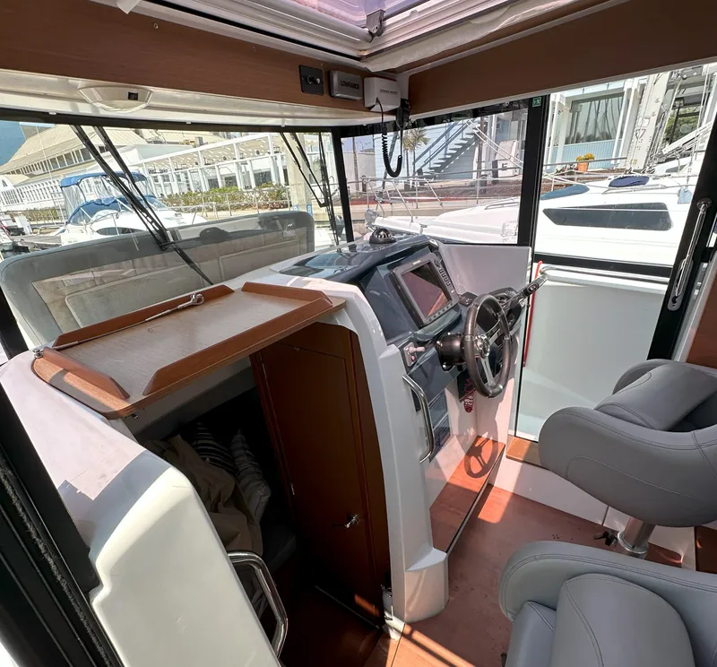 Slide: The Image of Interior of 2012 Beneteau Barracuda 9 Fly boat with steering console and seating. - 16