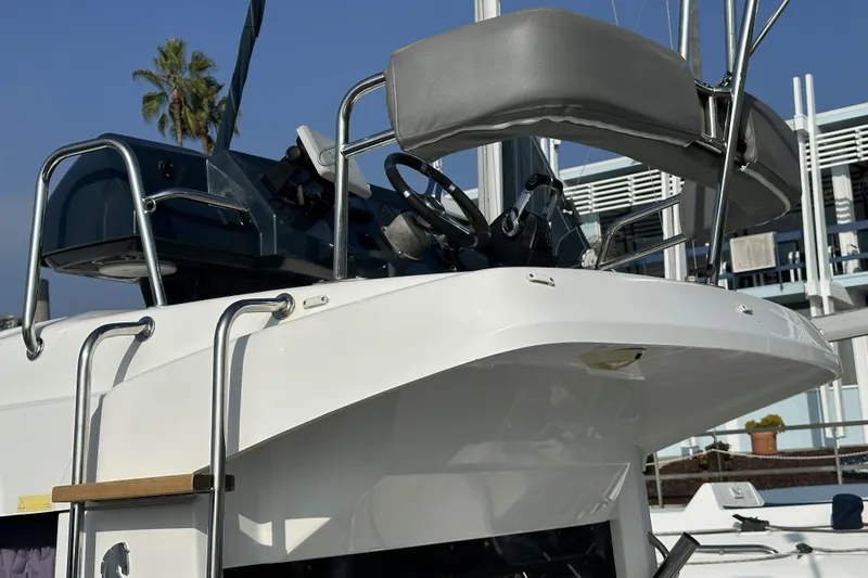 Slide: The Image of 2012 Beneteau Barracuda 9 boat helm with steering wheel and seating, docked outdoors. - 23