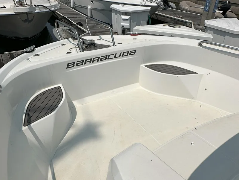 Slide: The Image of Beneteau Barracuda 9 Fly 2012 boat deck with "Barracuda" branding, docked at marina. - 9
