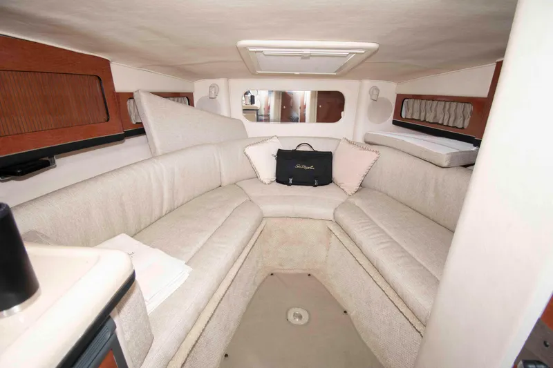 Slide: The Image of Interior of 2004 Sea Ray 290 Sun Sport boat with beige seating and wood accents. - 13