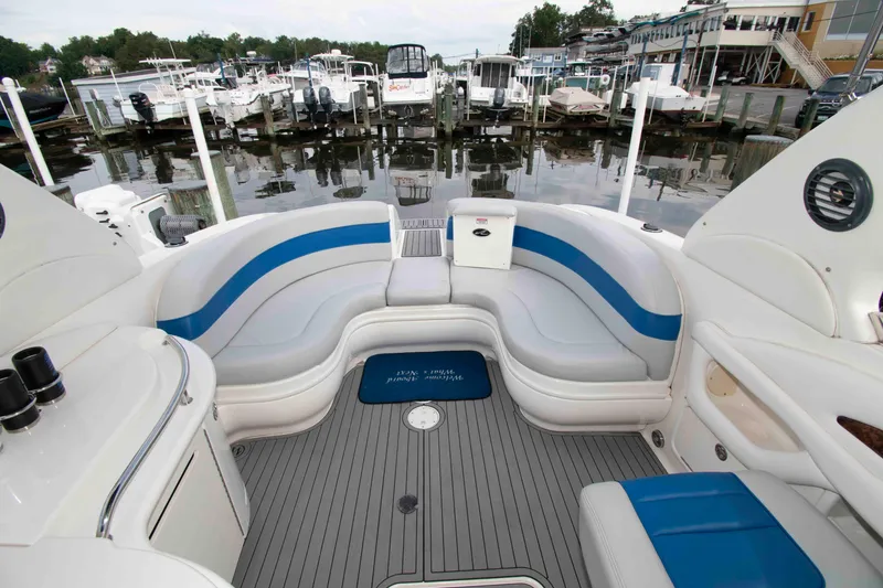 Slide: The Image of 2004 Sea Ray 290 Sun Sport boat interior with blue and white seating at marina. - 5