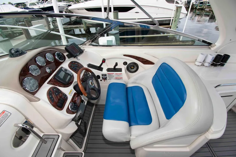 Slide: The Image of 2004 Sea Ray 290 Sun Sport helm with blue seating and control panel. - 6