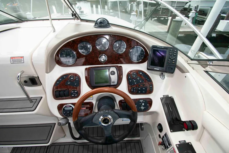 Slide: The Image of 2004 Sea Ray 290 Sun Sport dashboard with gauges, steering wheel, and navigation system. - 9