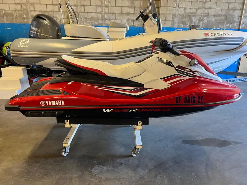 The Image of 2019 Yamaha WaveRunner EX Deluxe in red and white, displayed indoors on a stand. - 0