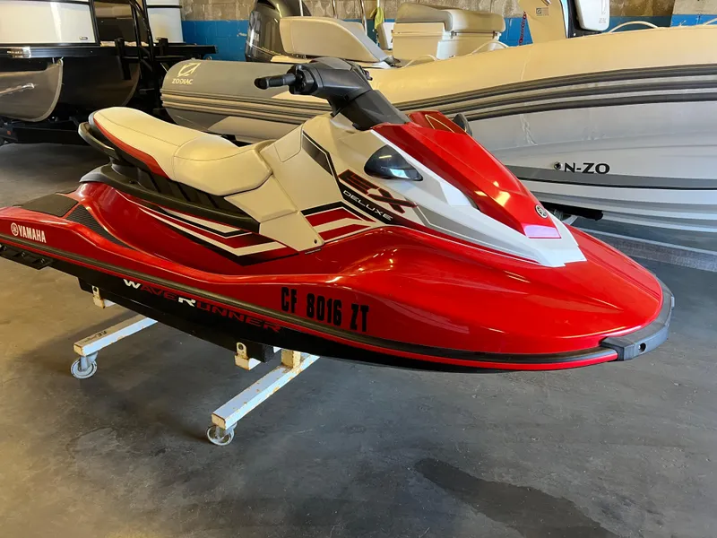 Slide: The Image of 2019 Yamaha WaveRunner EX Deluxe in vibrant red, displayed indoors. - 2