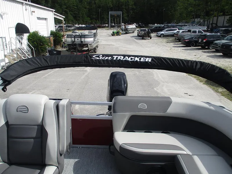 Slide: The Image of 2026 Sun Tracker Bass Buggy 16 XL Select pontoon boat interior at a marina. - 23
