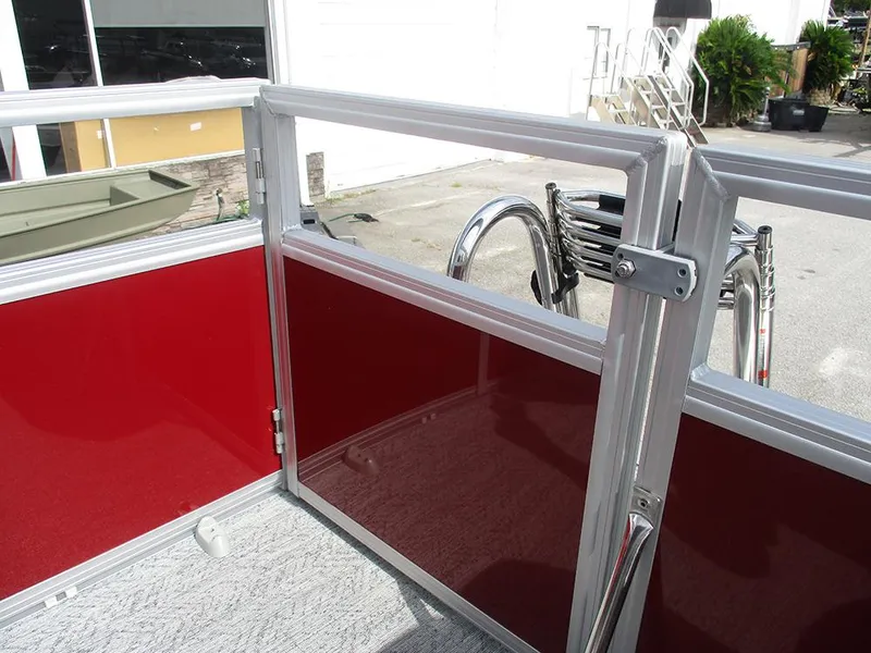 Slide: The Image of 2026 Sun Tracker Bass Buggy 16 XL Select pontoon boat with red paneling and metal railing. - 24