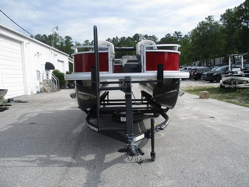 Slide: The Image of 2026 Sun Tracker Bass Buggy 16 XL Select pontoon boat on trailer, parked outdoors. - 5