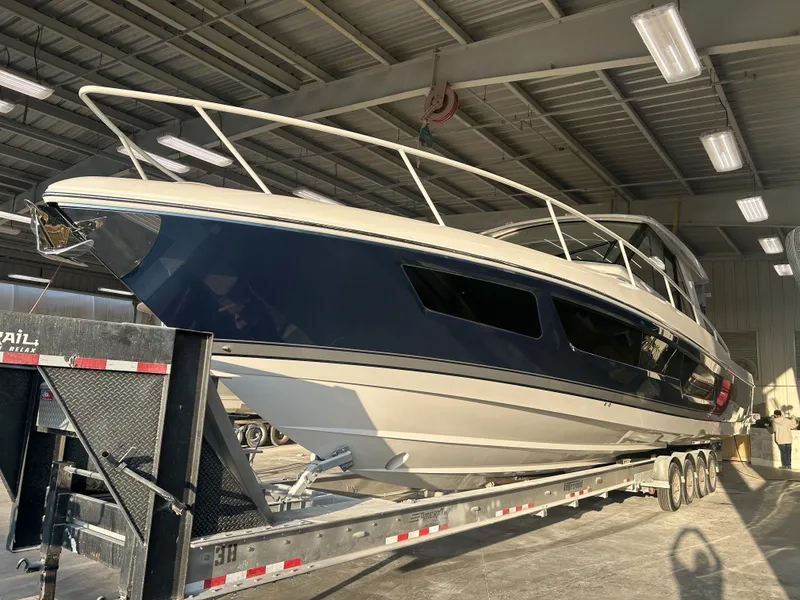 The Image of 2025 Intrepid 50 Evolution yacht on trailer in a well-lit indoor facility. - 0