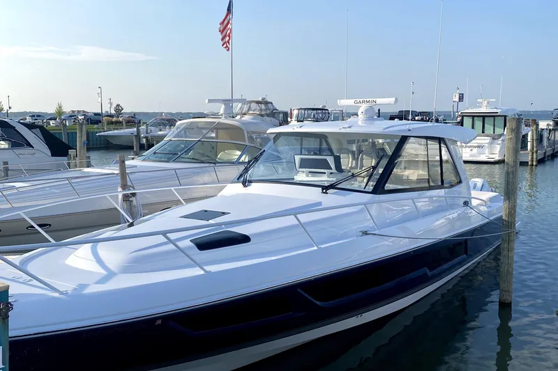 Slide: The Image of 2025 Intrepid 50 Evolution boat with white seating and Mercury outboard engines at a dock. - 11