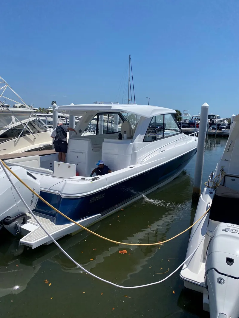 Slide: The Image of 2025 Intrepid 50 Evolution yacht docked at marina under clear blue sky. - 2