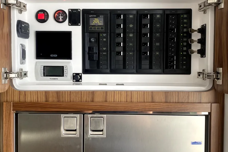 Slide: The Image of Control panel of 2025 Intrepid 50 Evolution yacht with various switches and displays. - 25