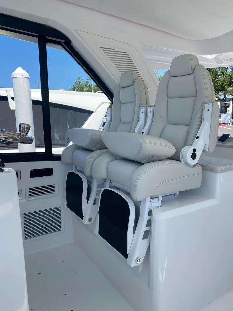 Slide: The Image of 2025 Intrepid 50 Evolution yacht docked at marina, surrounded by other boats. - 4