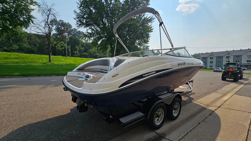 Slide: The Image of 2011 Yamaha SX210 boat on trailer, parked on a suburban street. - 4