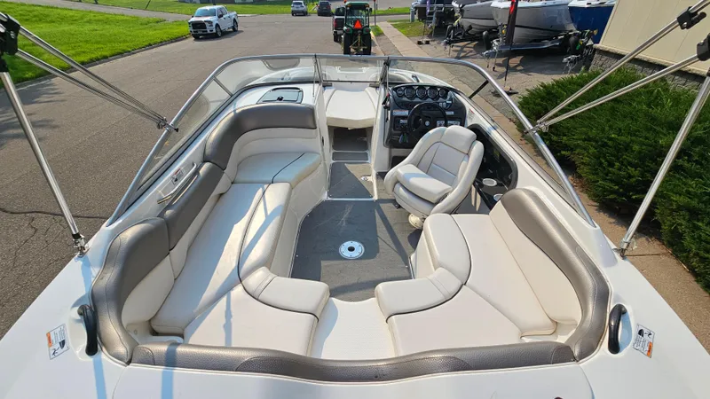 Slide: The Image of 2011 Yamaha Boats SX210 interior with seating and steering wheel, parked on a street. - 6