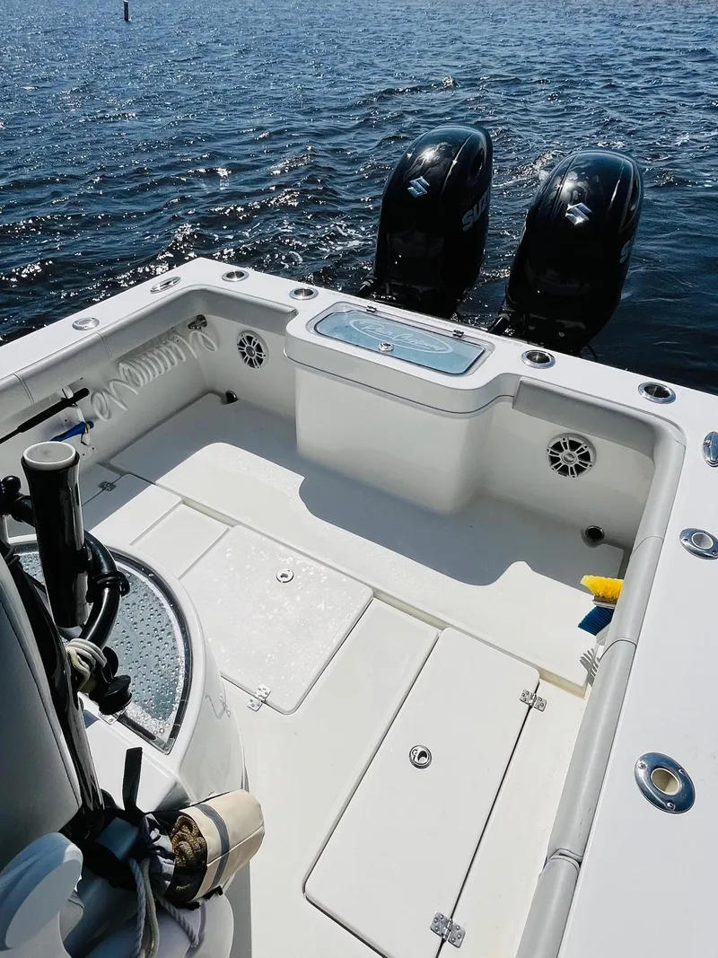 Slide: The Image of 2023 Pair Customs 24 Center Console DV boat with dual Suzuki outboard motors on water. - 15
