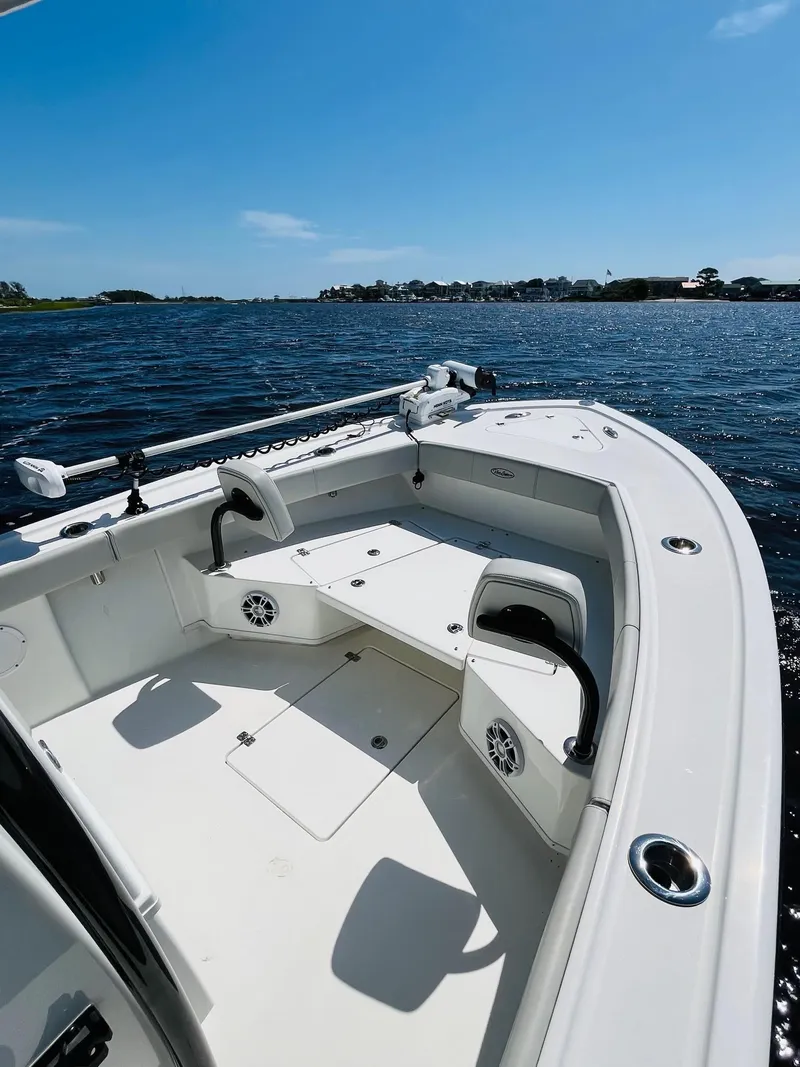 Slide: The Image of 2023 Pair Customs 24 Center Console DV boat on water, clear sky, lush shoreline. - 7