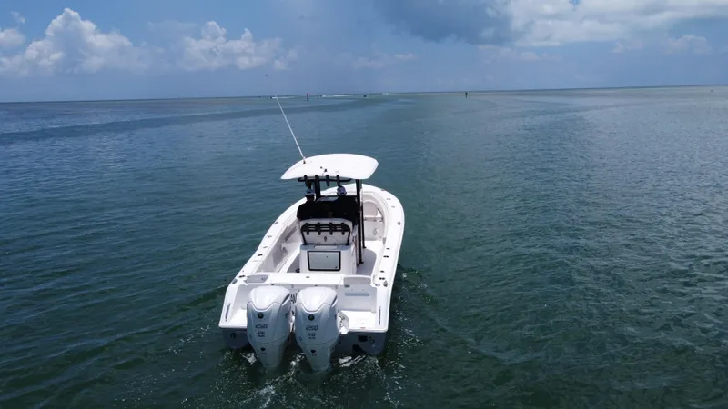 Slide: The Image of 2024 Sea Hunt Gamefish 27 boat on open water, featuring dual engines and forward seating. - 14