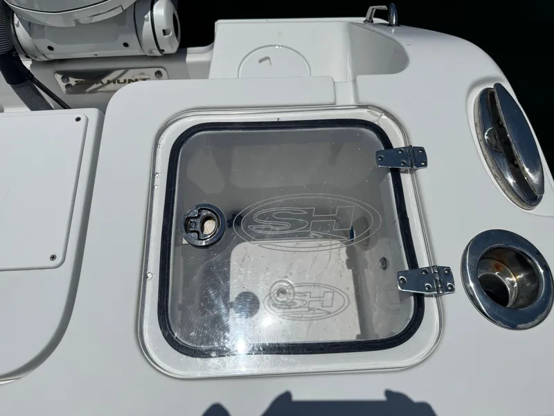 Slide: The Image of 2024 Sea Hunt Gamefish 27 Forward Seating boat hatch with clear cover and metal hinges. - 18
